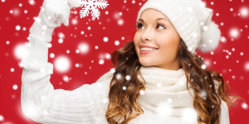 winter, people, happiness concept - woman in hat, muffler and gloves with big snowflake